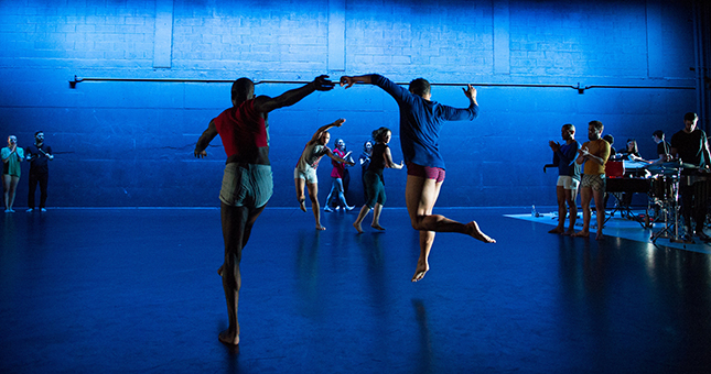 Dancers in a blue-hued studio